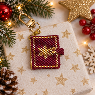 Minibuch Weihnachten aus dunkelroten und goldenen Perlen mit Sternmotiv und goldenem Karabiner