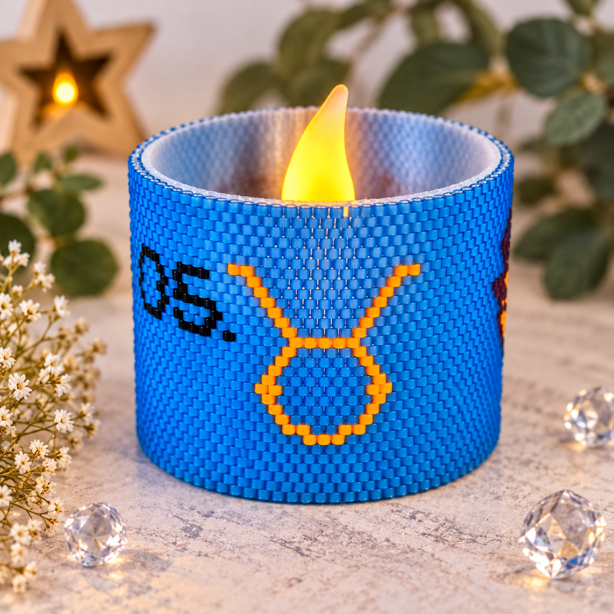 Windlichtumrandung Stier aus blauen Perlen mit orangefarbenem Sternzeichen-Symbol und LED-Teelicht